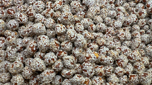 Sesame-coated peanuts lie in a random order on the display case.