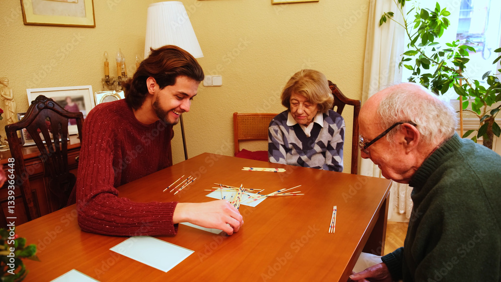 Happy grandmother having fun with her family playing mikado at home