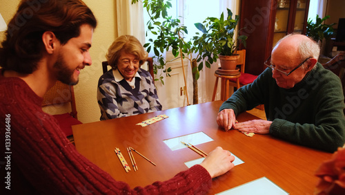 Obraz na płótnie Grandparents and grandson having fun together playing pick up sticks at home w salonie