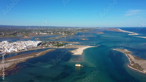 Aerial view of Fuseta Portugal showing the coastal landscape of the Ria Formosa lagoon with its sandy islands turquoise waters and the iconic lifeboat station on stilts