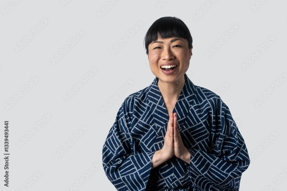 portrait of mature asian woman wearing traditional kimono isolated on grey background. 