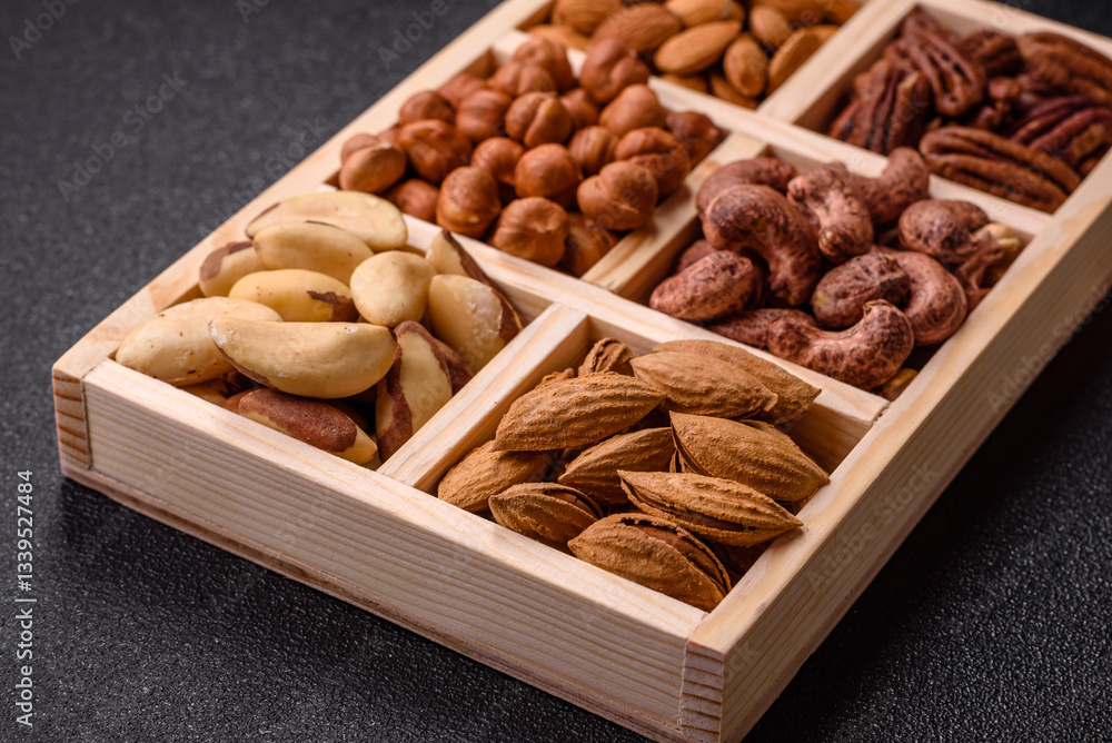 Fototapeta premium Wooden box with nuts cashew, hazelnut, almond, brazil, pecan, walnut