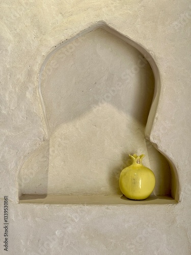 Wallpaper Mural Yellow pomegranate placed in an arched alcove on a textured wall Torontodigital.ca