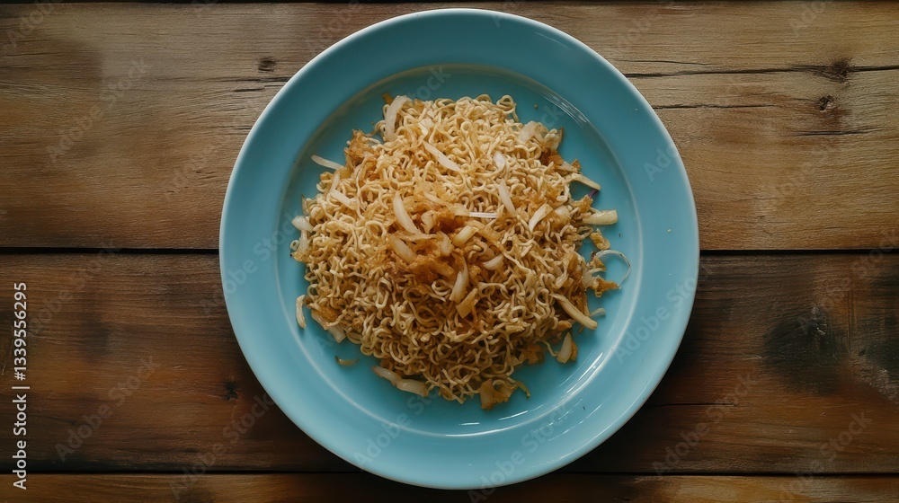 Fried instant noodle with garlic and onion on blue plate Fried instant noodle with garlic and onion on blue plate