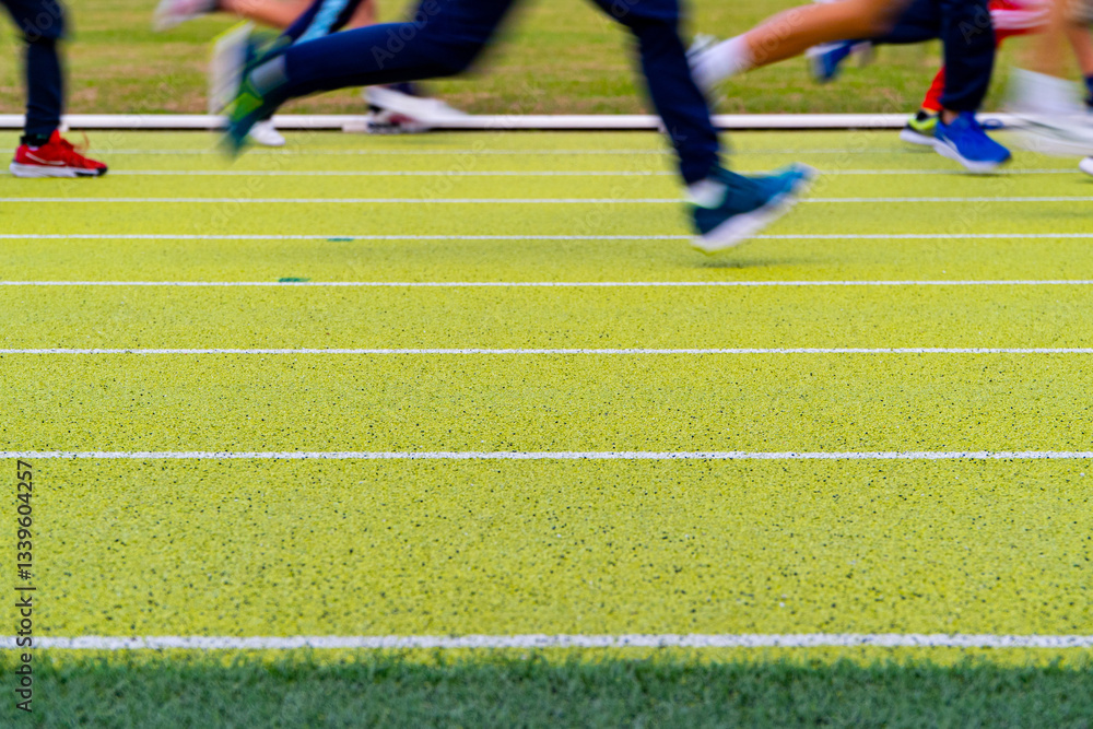 Cropped view of athletes running on track in stadium Cropped view of athletes running on track in stadium