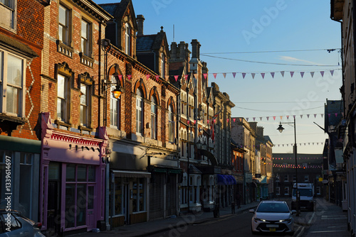 Obraz na płótnie Beautiful historic architecture at golden hour in Swindon, UK. Decorated Wood street in old town. Colorful shop fronts and sun reflection from the windows. Quiet street in the morning. w salonie
