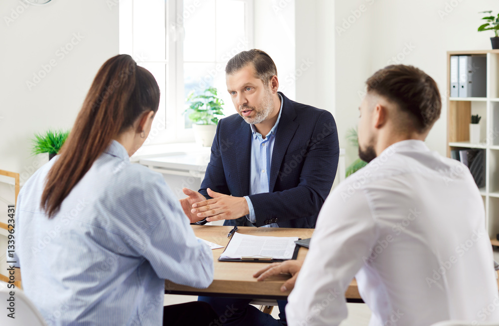 Family couple is communicating with a real estate agent or property consultant during a meeting in an office. The professional interaction highlights client service and property discussions. Family couple is communicating with a real estate agent or property consultant during a meeting in an office. The professional interaction highlights client service and property discussions.