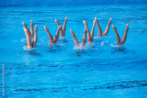 Canvas-taulu Artistic swimmers team performing synchronized legs choreographed movement in th