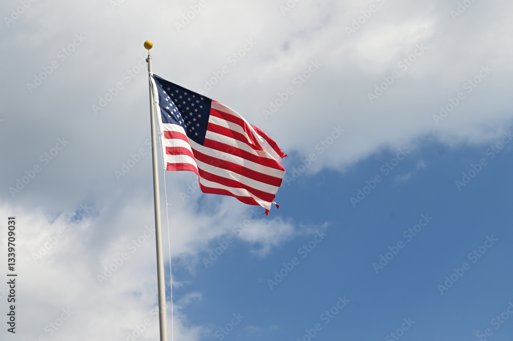 Close up full frame of United States of America flag flying in the wind with blue sky background Close up full frame of United States of America flag flying in the wind with blue sky background