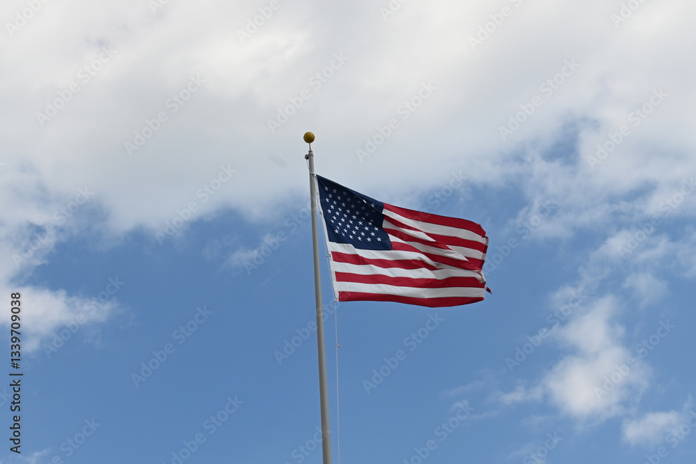 Fototapeta premium Close up full frame of United States of America flag flying in the wind with blue sky background