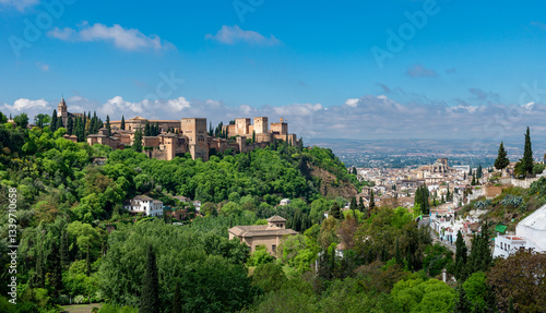 Granada, Spain - the majestic Alhambra palace overlooking the lush green hills and historic Albaicín district under a clear blue sky