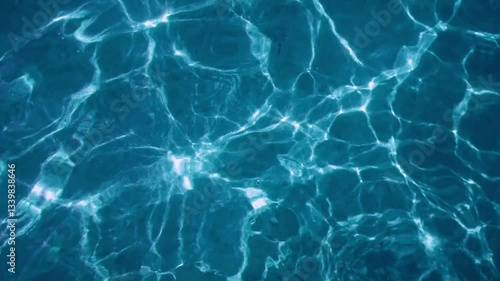 Background of transparent blue sea water glares under the rays of the sun. Sun glare at the bottom of the sea. Top view. Ripple water.