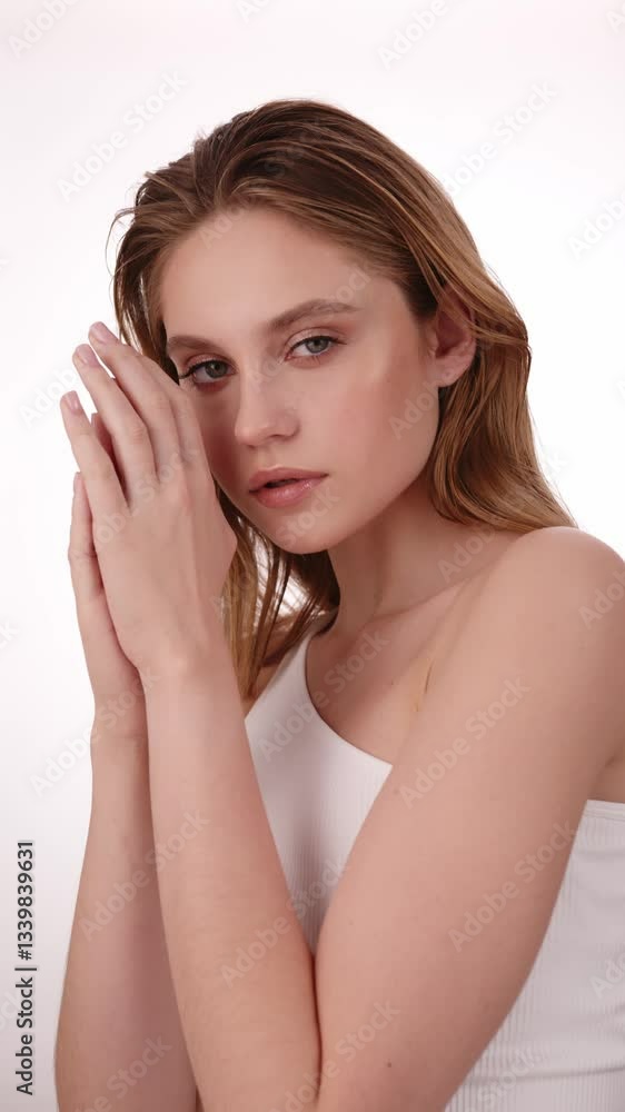 Beautiful woman in white top, blonde hair and neat makeup poses for the camera. Beauty face. Beautiful woman in white top, blonde hair and neat makeup poses for the camera. Beauty face.