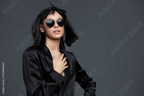 Wallpaper Mural Woman, black shirt, sunglasses a woman in a black shirt and sunglasses confidently poses with her hands on her hips against a gray background, showcasing a bold and stylish demeanor Torontodigital.ca