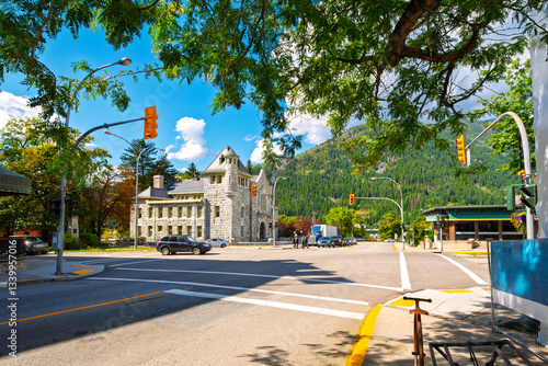 Fototapeta Naklejka Na Ścianę i Meble -  A picturesque shady street with the Nelson Courthouse in view at the small rural artist community mountain town of Nelson, BC, Canada.