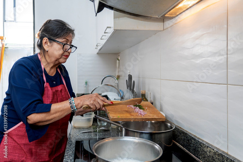 Senior latin woman preparing ingredients while cooking at home
