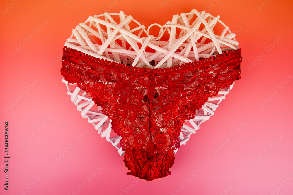 Red lace panty draped over a woven white heart, set against a gradient red-pink background. A sensual and romantic composition, perfect for love themes, lingerie advertising, or intimate fashion.