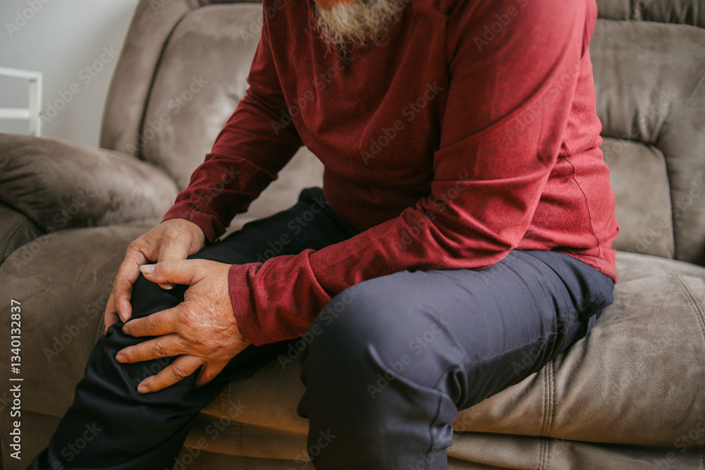 Close Up Shot Of Old Man Suffering From Knee Pain Sitting On Sofa Close Up Shot Of Old Man Suffering From Knee Pain Sitting On Sofa