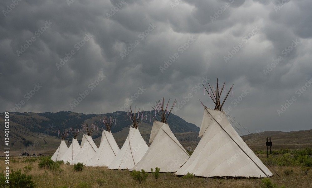 Seven Teepees Fill The Frame Below Storm Clouds