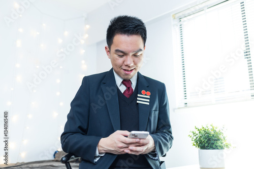 A high school student using his phone in his room