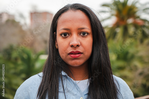 Foto Confident woman with long hair looking directly at the camera with a serious exp