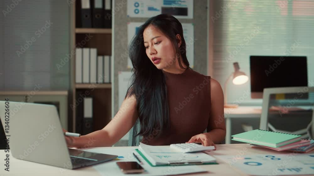 Asian businesswoman working with laptop and calculator in office Asian businesswoman working with laptop and calculator in office