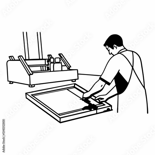 Male worker pressing ink on frame while using the printing machine in a workshop
