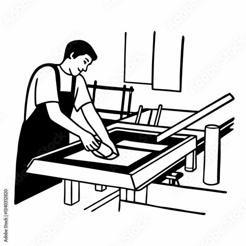 Male worker pressing ink on frame while using the printing machine in a workshop
