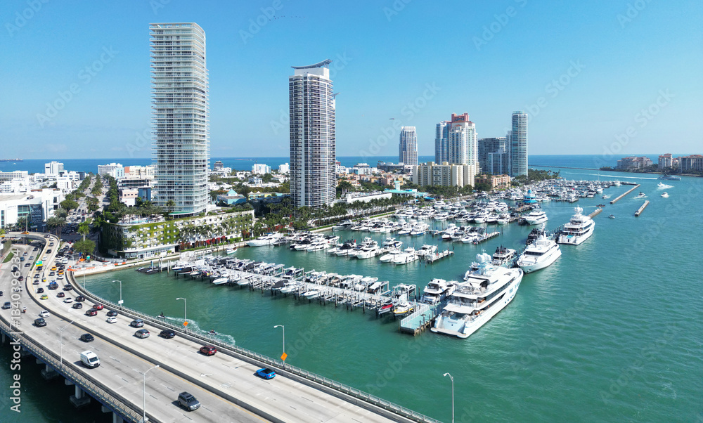 Fototapeta premium Miami Beach on blue sky. Skyline aerial view. Miami city. Tropical Miami scene. Miami district sky view. Famous oceanfront. Panoramic coastline. South beach panorama view. Summer holiday vibes.