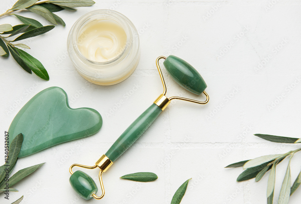 Gua sha stone, face roller and cream promoting skin care and relaxation