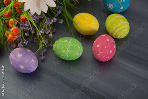 Colorful easter decoration with and flowers on gray wooden table. Top view