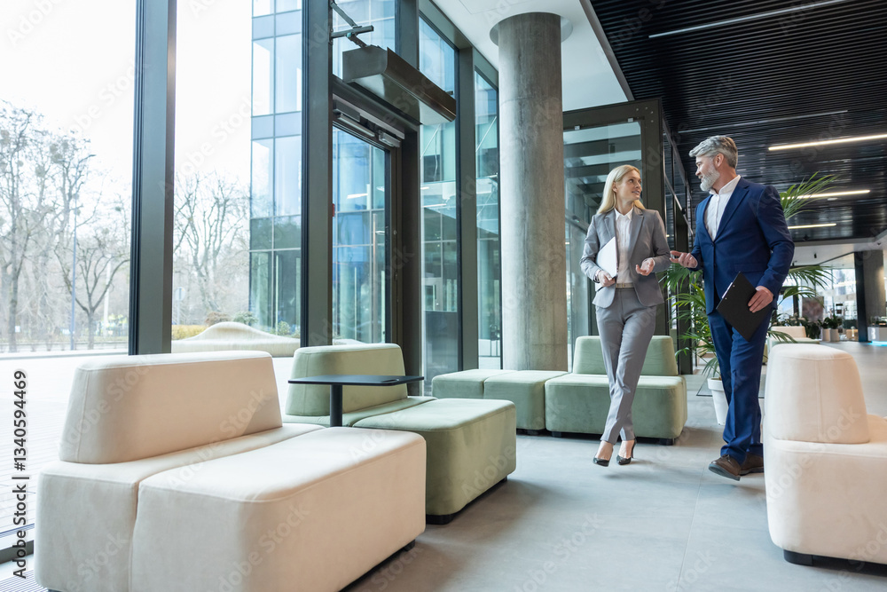 Fototapeta premium Business partners walking in the business center hall and talking