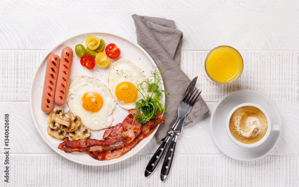 A classic breakfast plate featuring sunny-side-up eggs, crispy bacon, sausages, and fresh tomatoes A classic breakfast plate featuring sunny-side-up eggs, crispy bacon, sausages, and fresh tomatoes