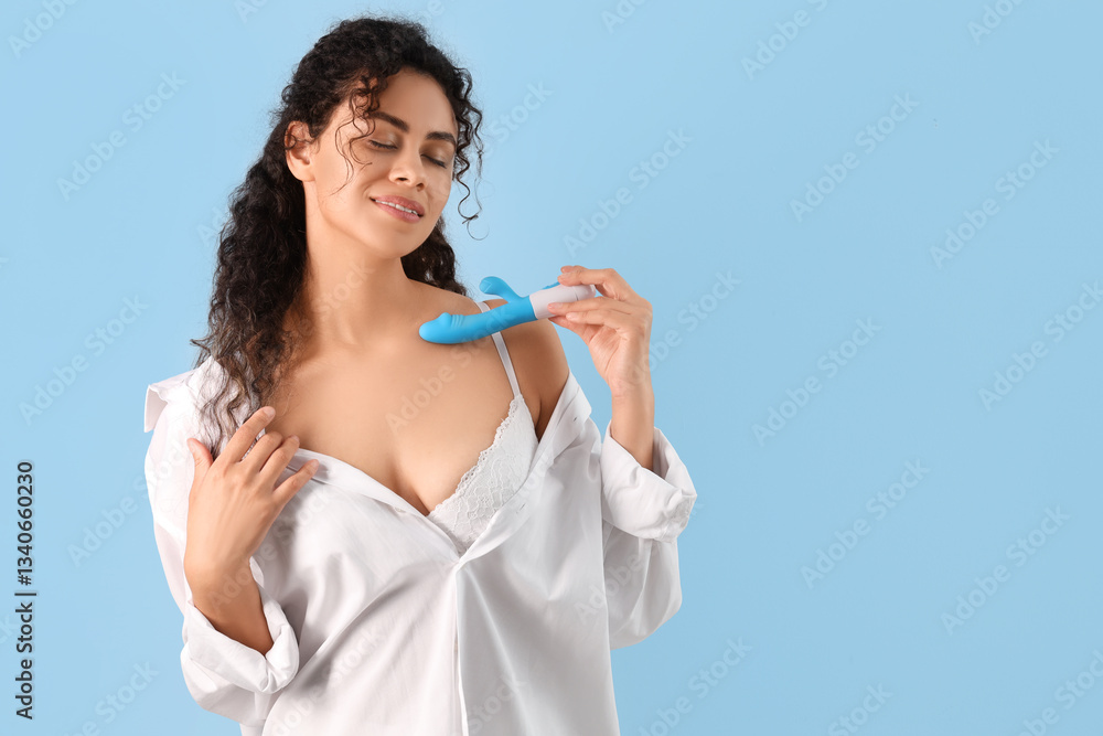 Young African-American woman with vibrator on light background Young African-American woman with vibrator on light background