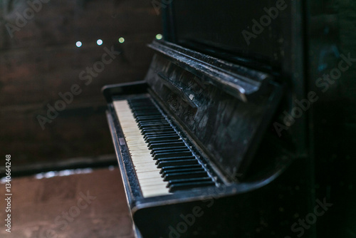 Canvas Print A vintage, upright piano with a distressed, black finish, showcasing its age and character, set against a simple backdrop