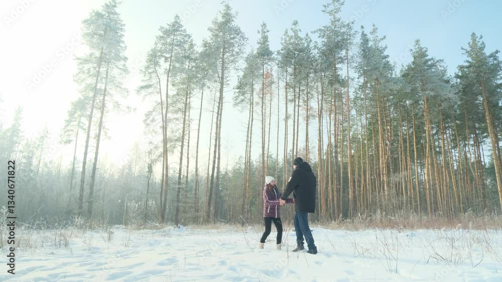 Couple in love runs during a winter walk in a snowy forest during the day Couple in love runs during a winter walk in a snowy forest during the day