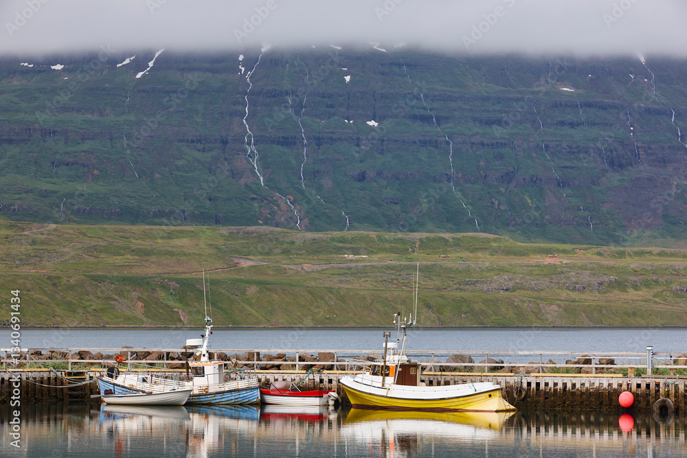 Fishing vessels docked at the pier. Seydisfjordur. Icelandic fjord landscape