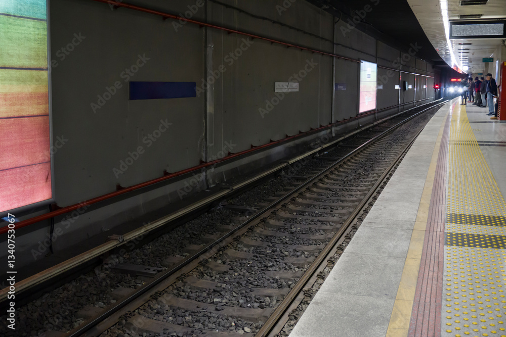 Subway train approaches the platform in a modern underground station with waiting passengers. Subway train approaches the platform in a modern underground station with waiting passengers.