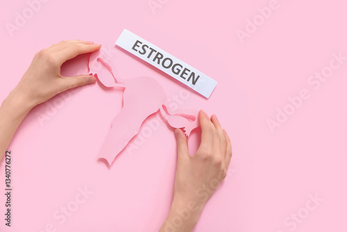 Woman holding paper uterus ...