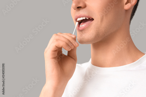 Young man with cotton bud o...