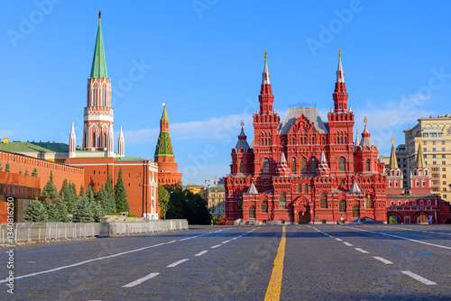 Red Square in Moscow, Russia, with the Kremlin walls and the State Historical Museum under a clear blue sky. The iconic cobblestone square is a famous landmark and a UNESCO World Heritage site
