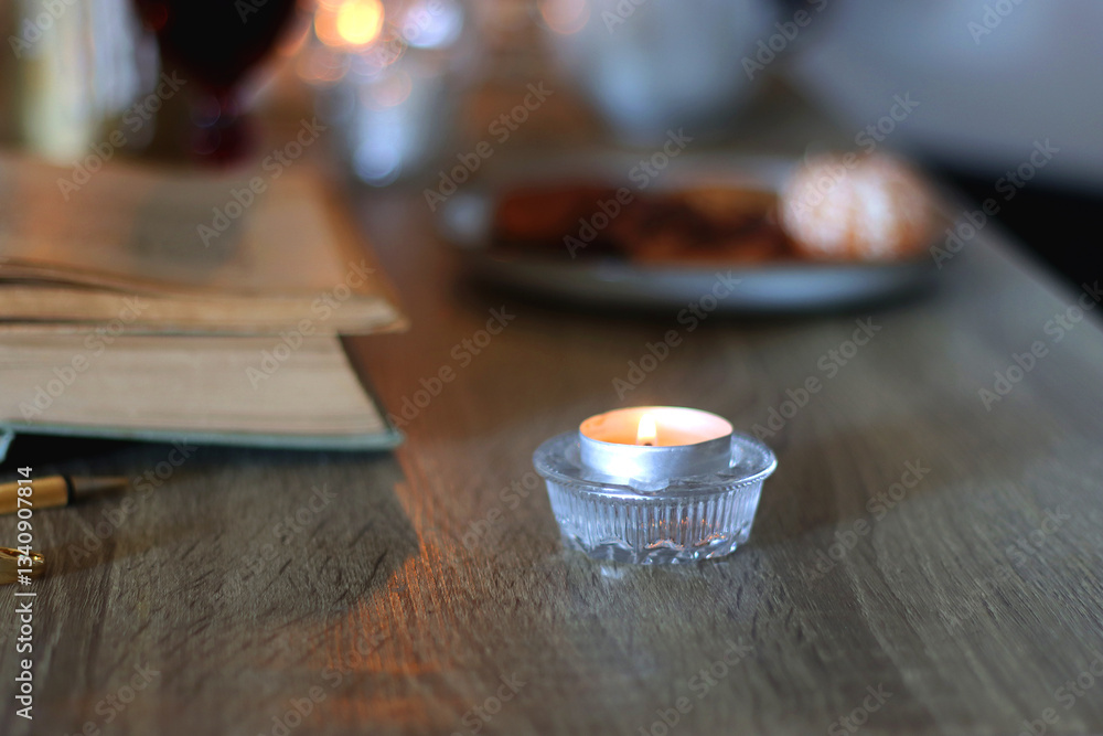 Books, lit candles, red wine, snacks and various deocration on the table. Dark academia or Halloween concept. Selective focus.