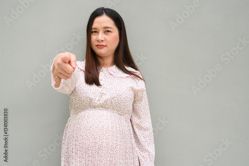 young pregnant woman pointing finger to viewer