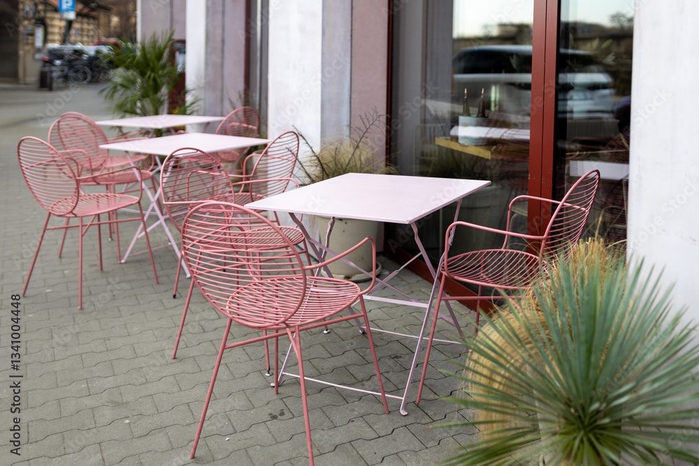 Modern outdoor terrace with seating arrangement. Fashionable outdoor restaurant tables, summer time. Tables and chairs at sidewalk cafe. Touristic setting, cafe table, sidewalk cafe furniture