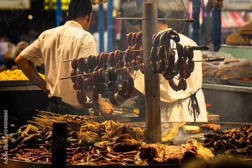 a street food BBQ cooking meat, sausage and chicken