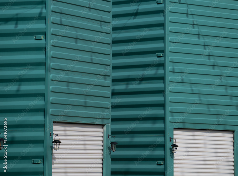 Fototapeta premium metal container on end or upright painted turquoise with white metal garage door and exterior light creative ways to use containers horizontal image room for type Base 31 Prince Edward County Ontario
