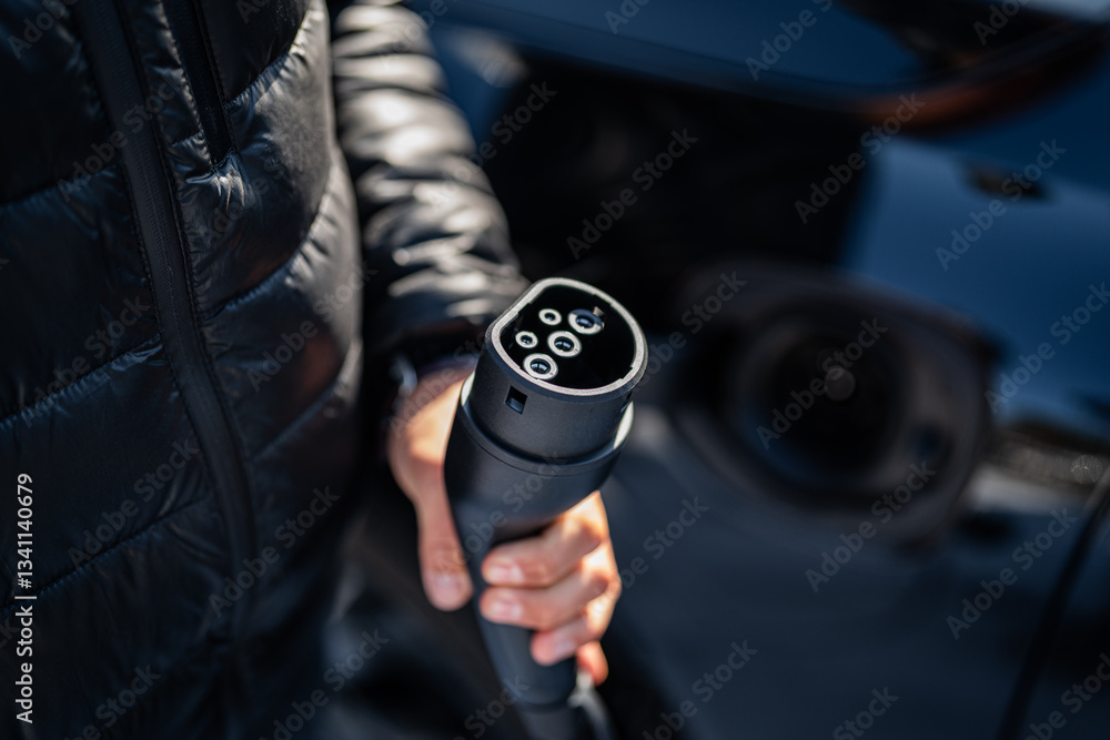 plug into socket - electric car - dark background - training in using a charger types of plugs and power adapters