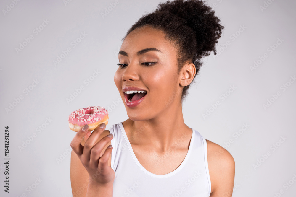 African American girl eating donut isolated. African American girl eating donut isolated.
