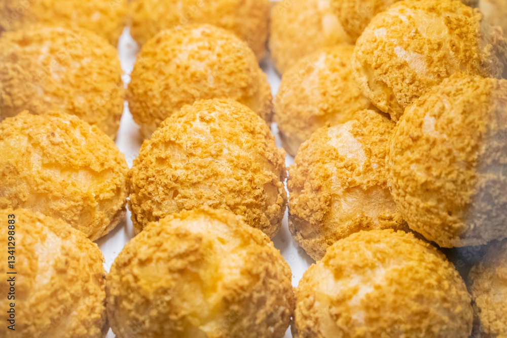 A beautifully designed restaurant communal space features sleek wooden benches positioned near a floor-to-ceiling glass facade, allowing natural light to flood the area. The warm tones of the wood