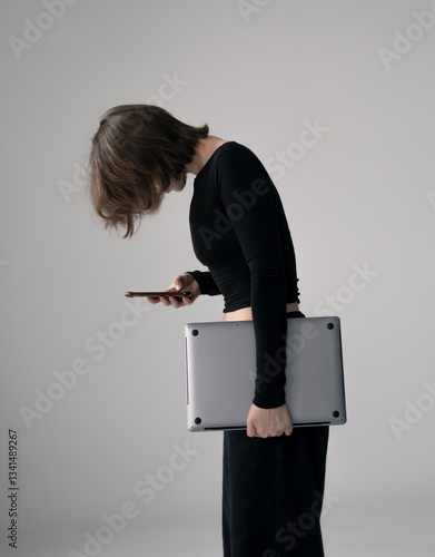 Woman hunched over phone with poor posture, sitting at desk, showing unhealthy work habits.